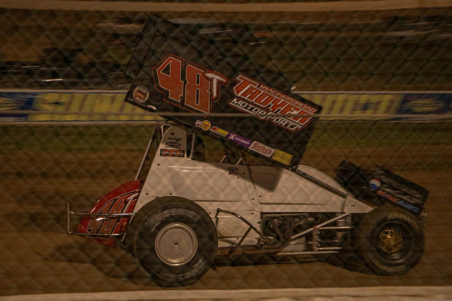 Sprint car racing on a dirt track at night