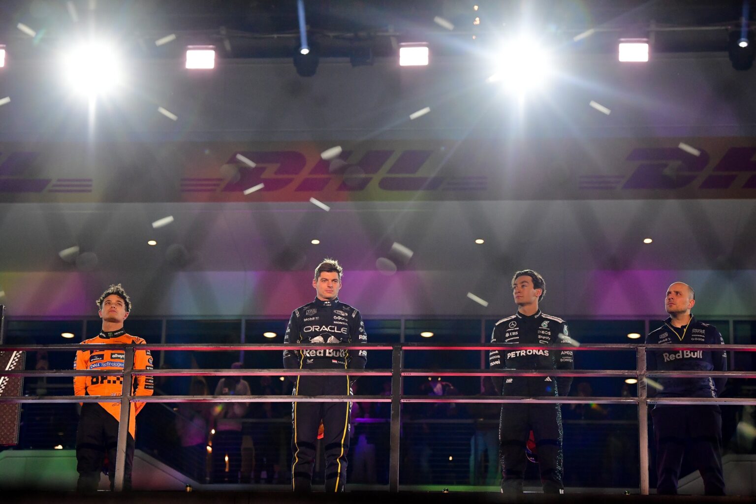 Nov 21, 2025; Las Vegas, NV, USA; McLaren driver Lando Norris (4) Red Bull Racing driver Max Verstappen (1) and Mercedes driver George Russell (63) on the podium with Red Bull Racing engineer Gianpiero Lambiase following the Las Vegas Grand Prix at Las Vegas Strip Circuit. Mandatory Credit: Gary A. Vasquez-Imagn Images