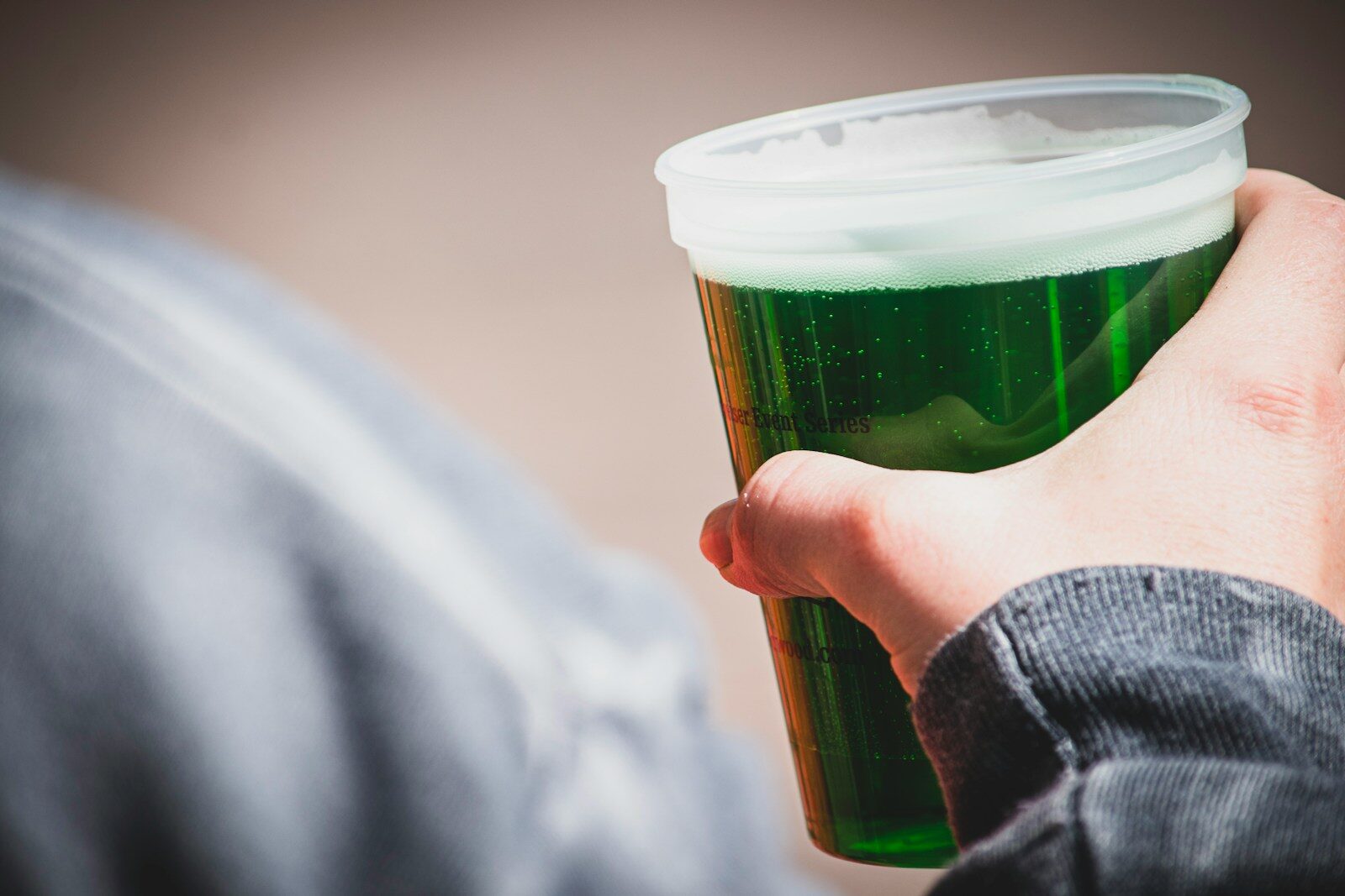 a hand holding a green cup
