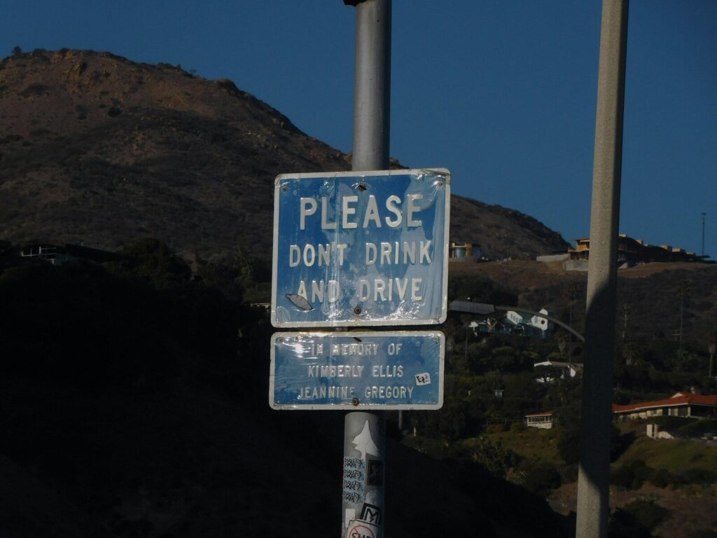 a blue and white street sign sitting on the side of a road. DUI
