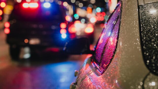 Police car with flashing lights on city street.