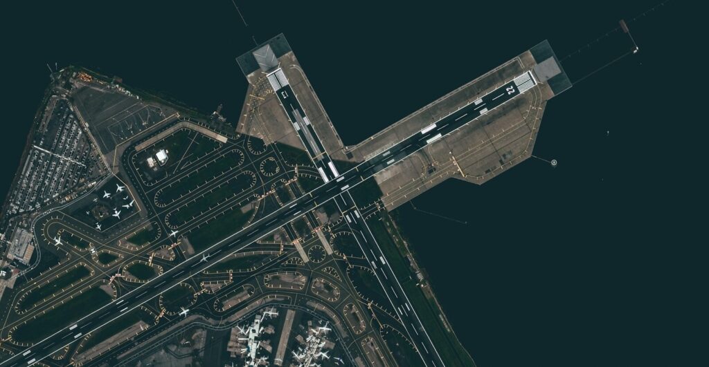 aerial view of city buildings during night time and aircraft