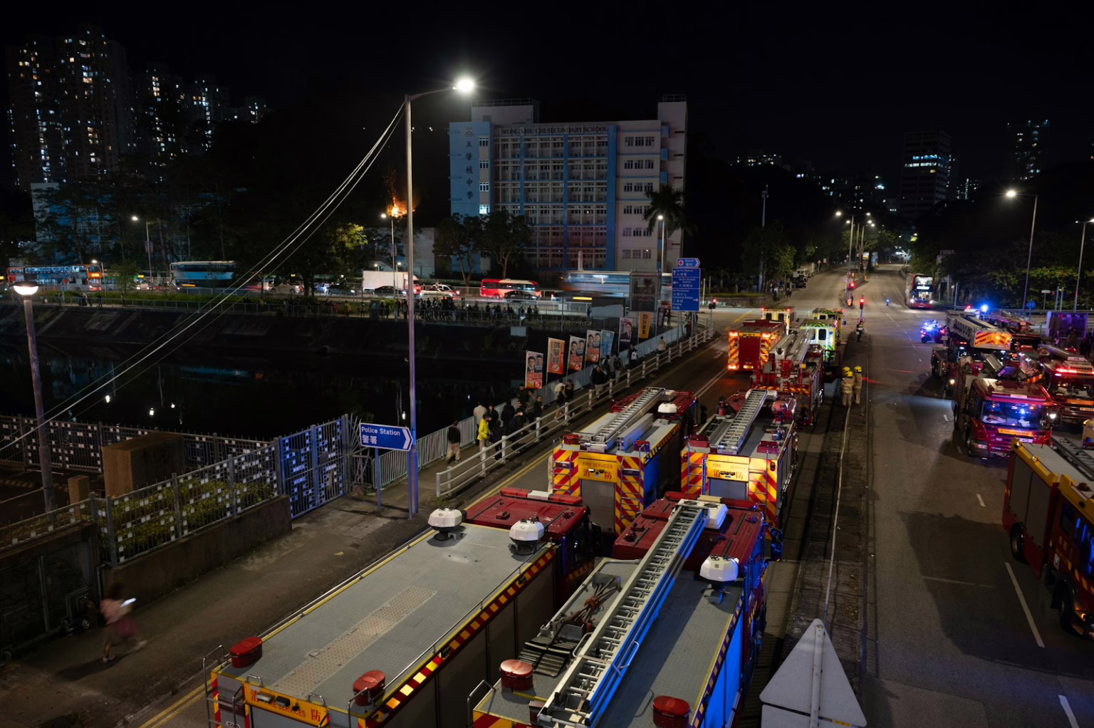 Emergency vehicles line a street at night.