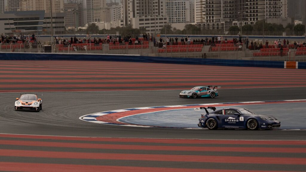 Race cars drift around a corner on a track. Porsche
