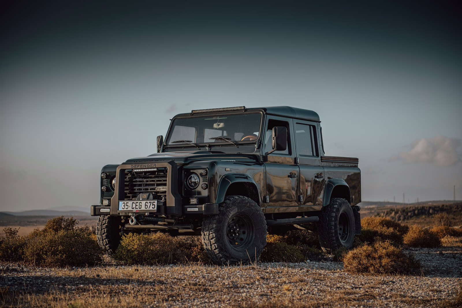 A black truck is parked in a field