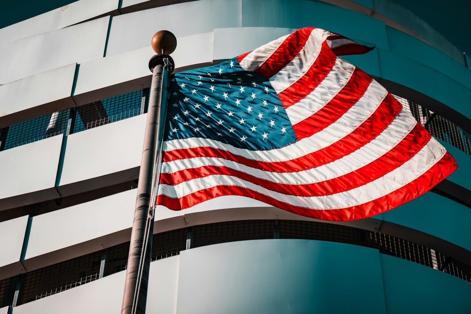 American flag waving in front of a modern building