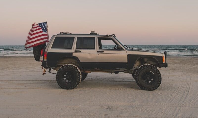 a jeep with an american flag on the beach