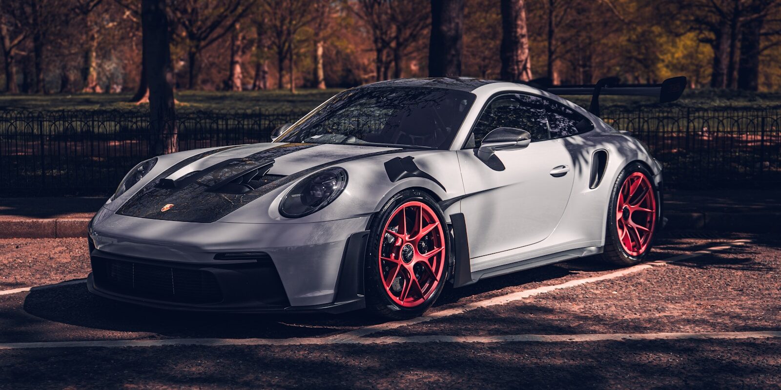 A sleek white porsche is parked outside.