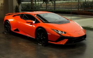 a bright orange sports car parked in a garage