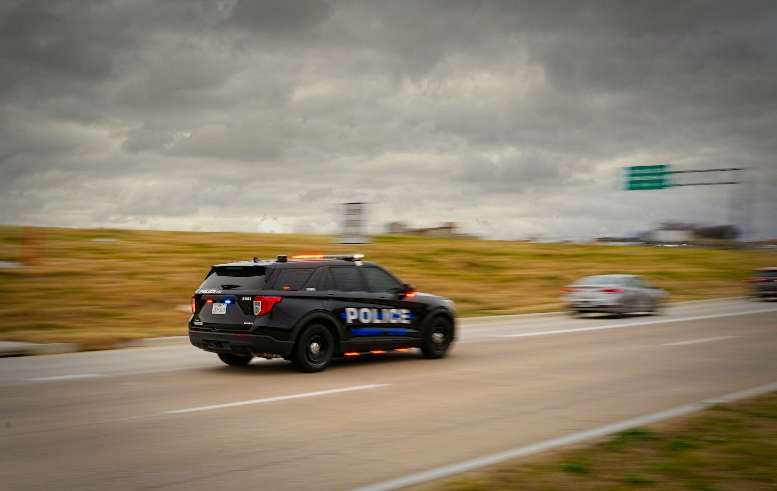 Police car driving on a highway with blurred background.
