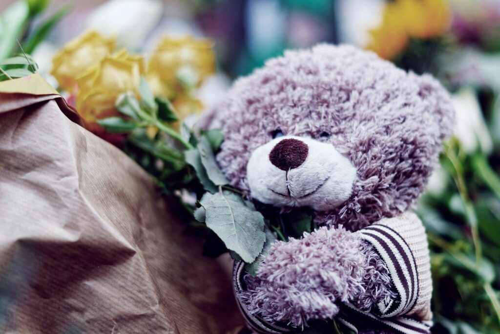 a teddy bear sits on a bench