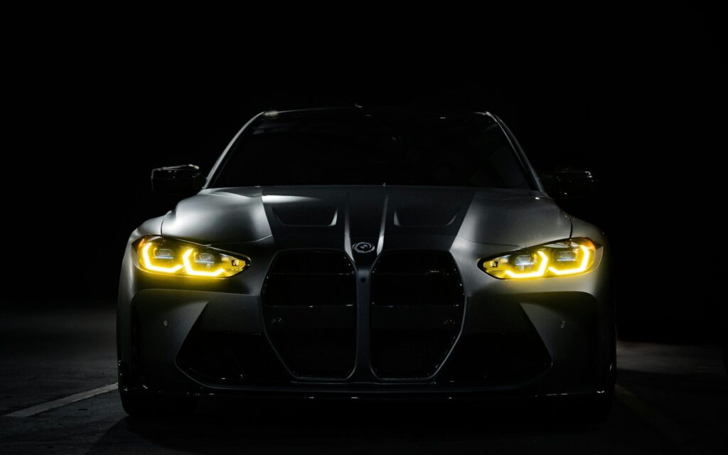 The front of a black sports car in the dark
