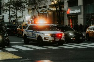 a police car driving down a street next to a motorcycle
