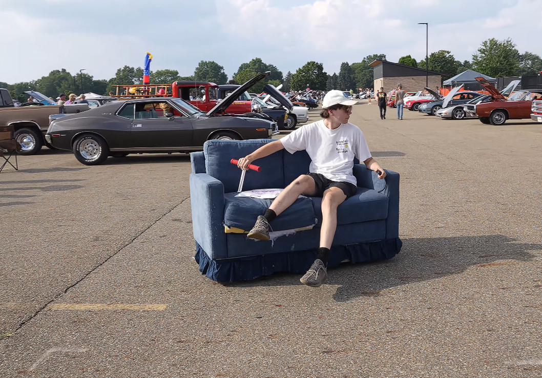 YouTuber Brings a Drivable Couch to a Car Meet, Instantly Enrages Porsche Owner