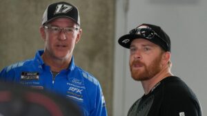 NASCAR Cup Series driver Chris Buescher (right) waits in the garage Friday, July 24, 2026, before practice for the Brickyard 400