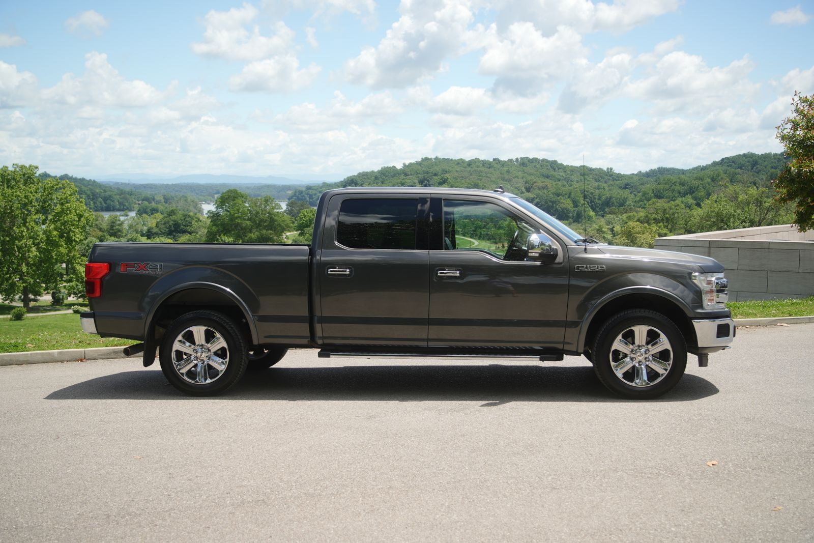 Side view of a Ford F-150 on a street in Knoxville, TN, with a scenic background.