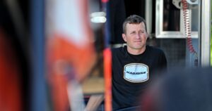 Former NASCAR driver Kasey Kahne sits near his car during the first night of the World of Outlaws Beaver Dam Bash on Friday,