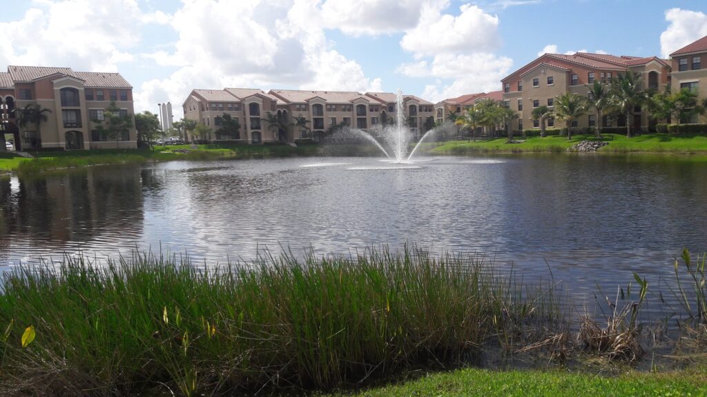Lake with a fountain and apartment buildings in Doral, Florida